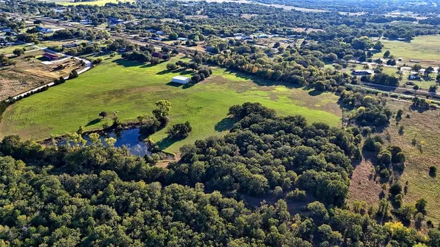 a view of a field with a trees in the background