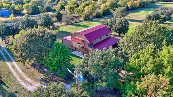 an aerial view of a house with a yard and lake view