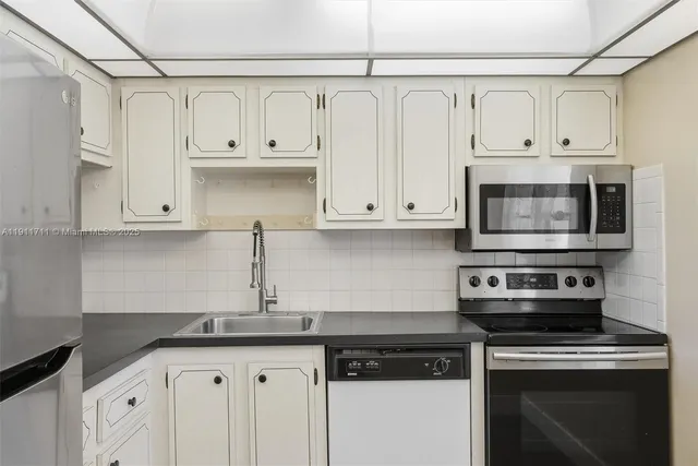 a kitchen with white cabinets and stainless steel appliances