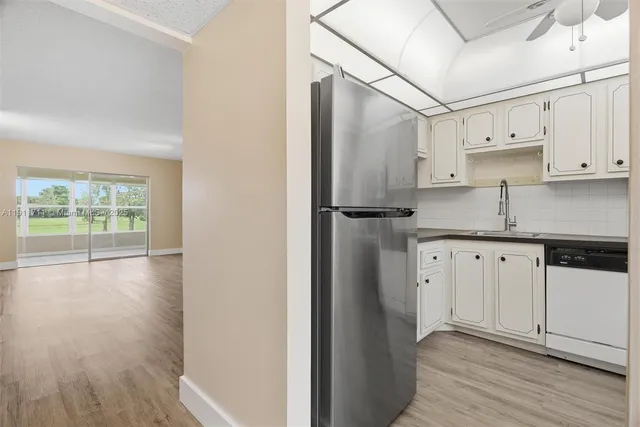 a kitchen with stainless steel appliances a refrigerator sink and cabinets