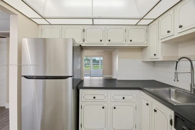 a kitchen with stainless steel appliances white cabinets and a refrigerator