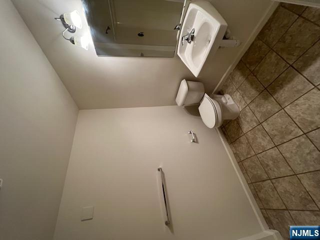 169 Barclay Street, Unit 105 Paterson, NJ 07503 - Photo 8 of 13 a bathroom with a toilet sink and mirror