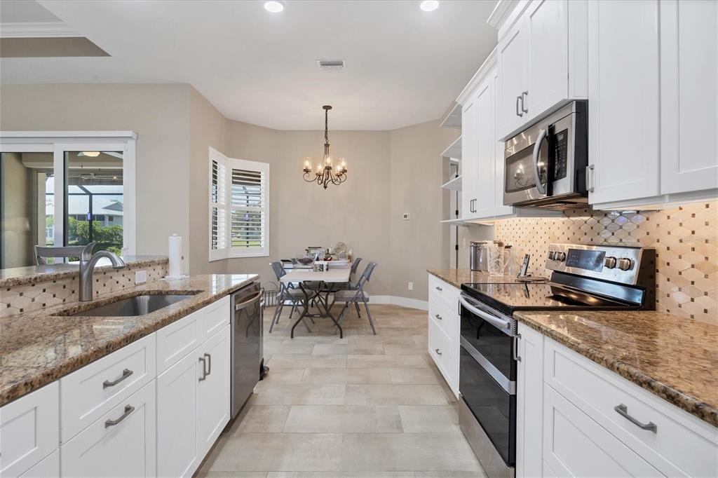 249 Rotonda Circle Rotonda West, FL 33947 - Photo 18 of 71 a large kitchen with stainless steel appliances granite countertop a sink and a stove