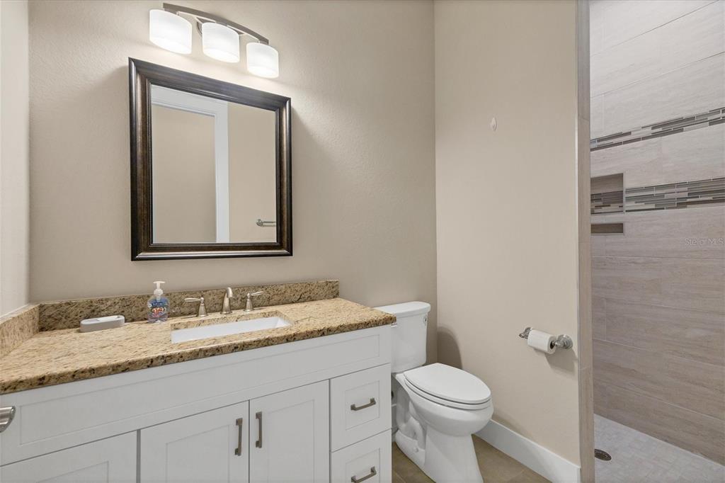 249 Rotonda Circle Rotonda West, FL 33947 - Photo 33 of 71 a bathroom with a granite countertop toilet sink and mirror