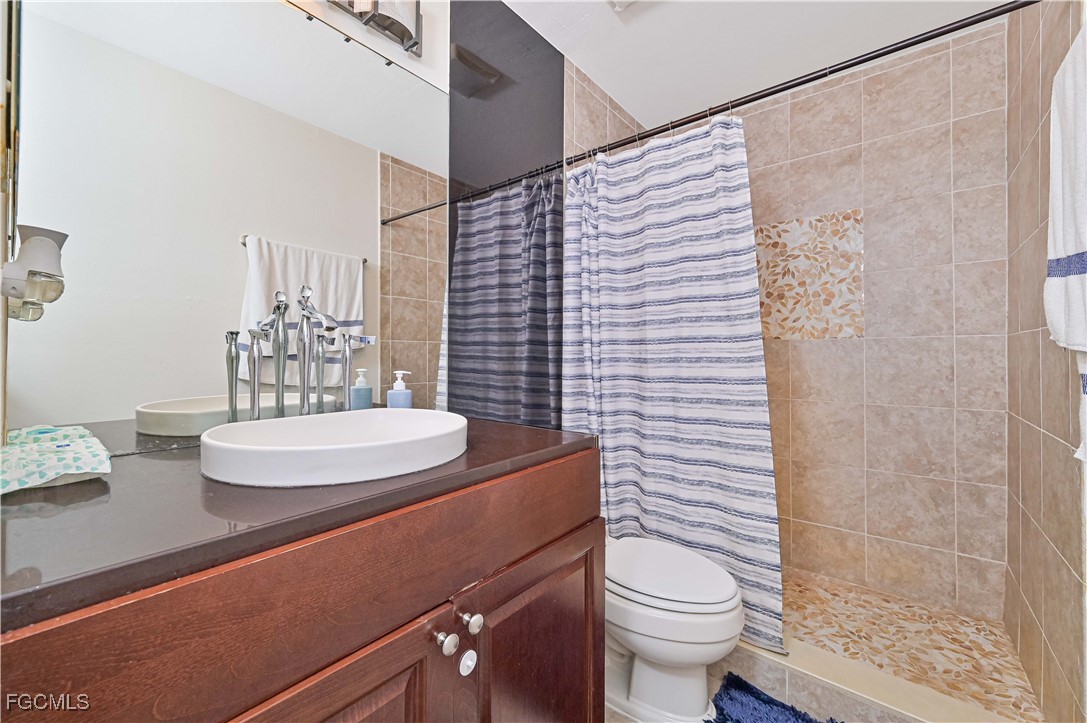 721-723 Homer Avenue South, Unit 723 Lehigh Acres, FL 33973 - Photo 17 of 36 a bathroom with a sink a toilet a shower and a mirror