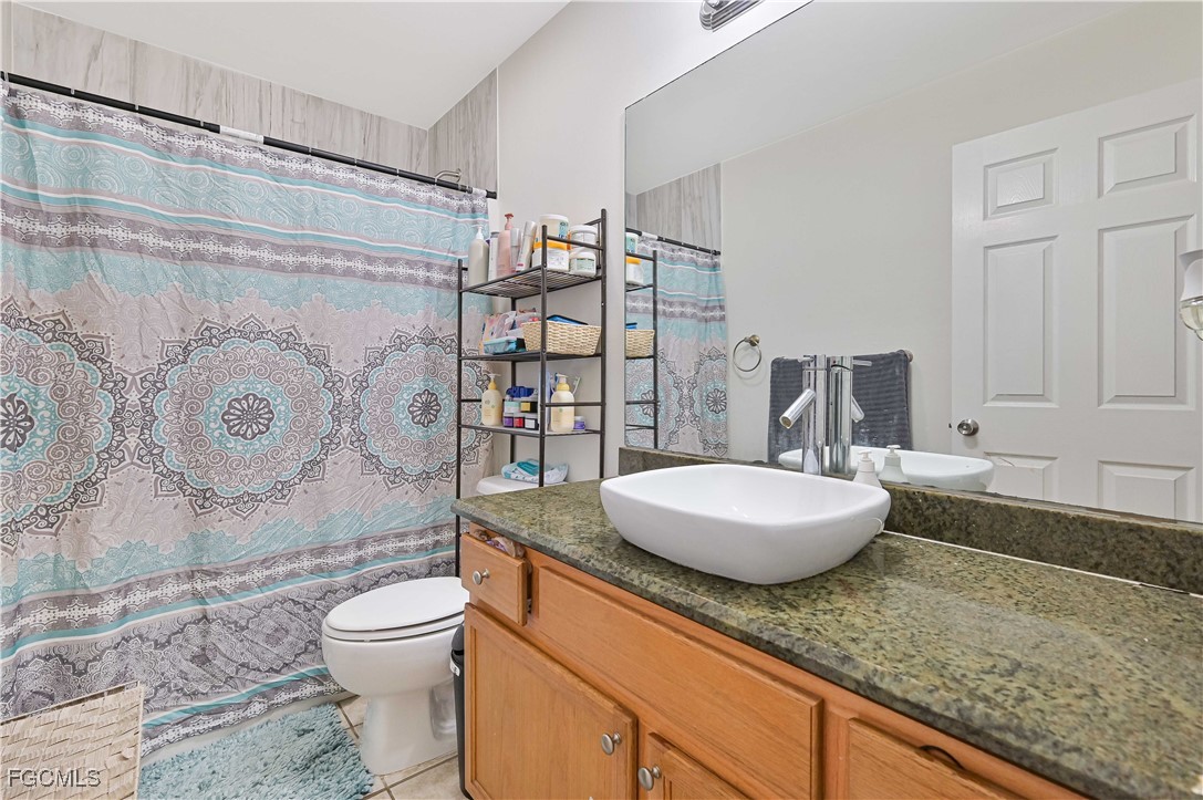 721-723 Homer Avenue South, Unit 723 Lehigh Acres, FL 33973 - Photo 20 of 36 a bathroom with a granite countertop toilet sink mirror vanity shower and a bathtub