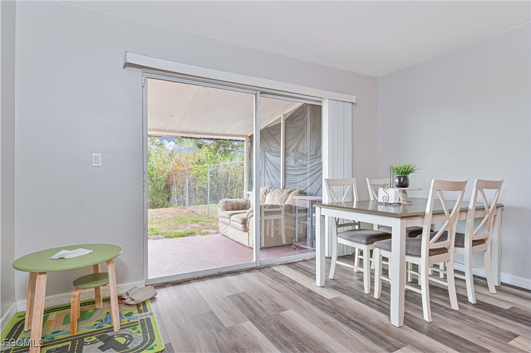 721-723 Homer Avenue South, Unit 723 Lehigh Acres, FL 33973 - Photo 23 of 36 a dining room with furniture a rug and a floor to ceiling window
