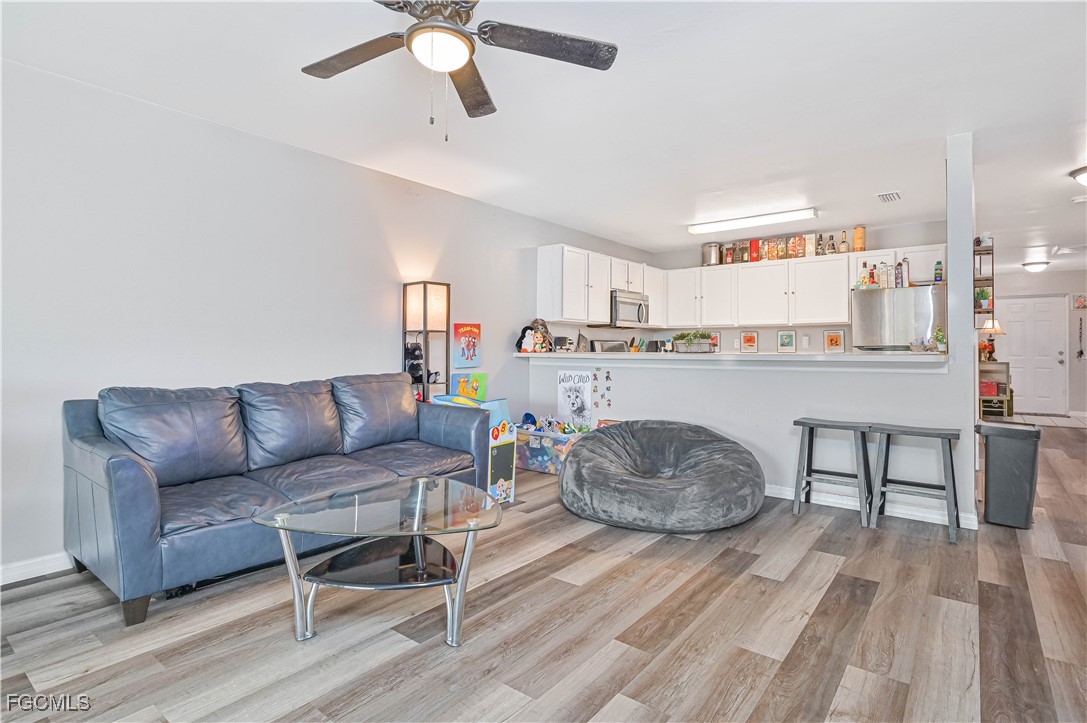 721-723 Homer Avenue South, Unit 723 Lehigh Acres, FL 33973 - Photo 24 of 36 a living room with furniture and a wooden floor
