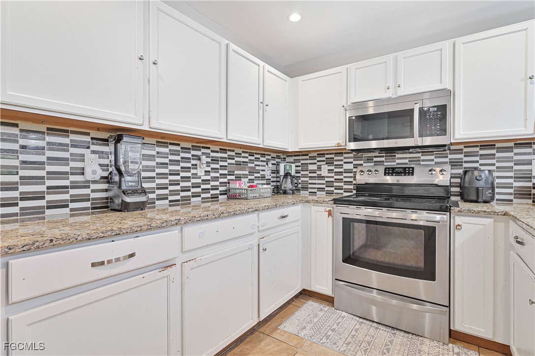 721-723 Homer Avenue South, Unit 723 Lehigh Acres, FL 33973 - Photo 10 of 36 a kitchen with granite countertop white cabinets stainless steel appliances and sink