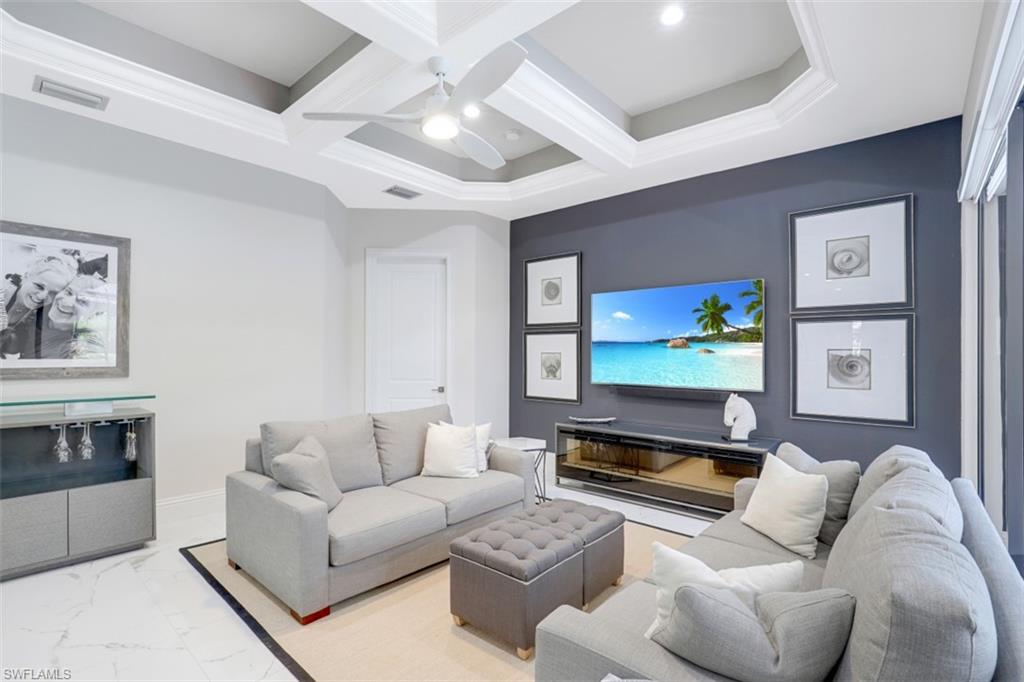 7323 Acorn Way Naples, FL 34119 - Photo 3 of 21 Living area featuring coffered ceiling, a ceiling fan, and tile floors