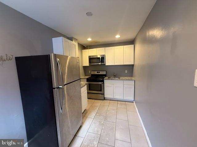 1224 Tasker Street, Unit 1R Philadelphia, PA 19148 - Photo 5 of 9 a kitchen with a refrigerator a microwave and cabinets