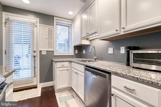 a kitchen with granite countertop cabinets stainless steel appliances and a counter space