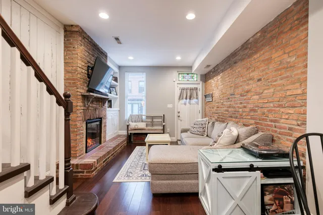 a living room with furniture a fireplace and a flat screen tv
