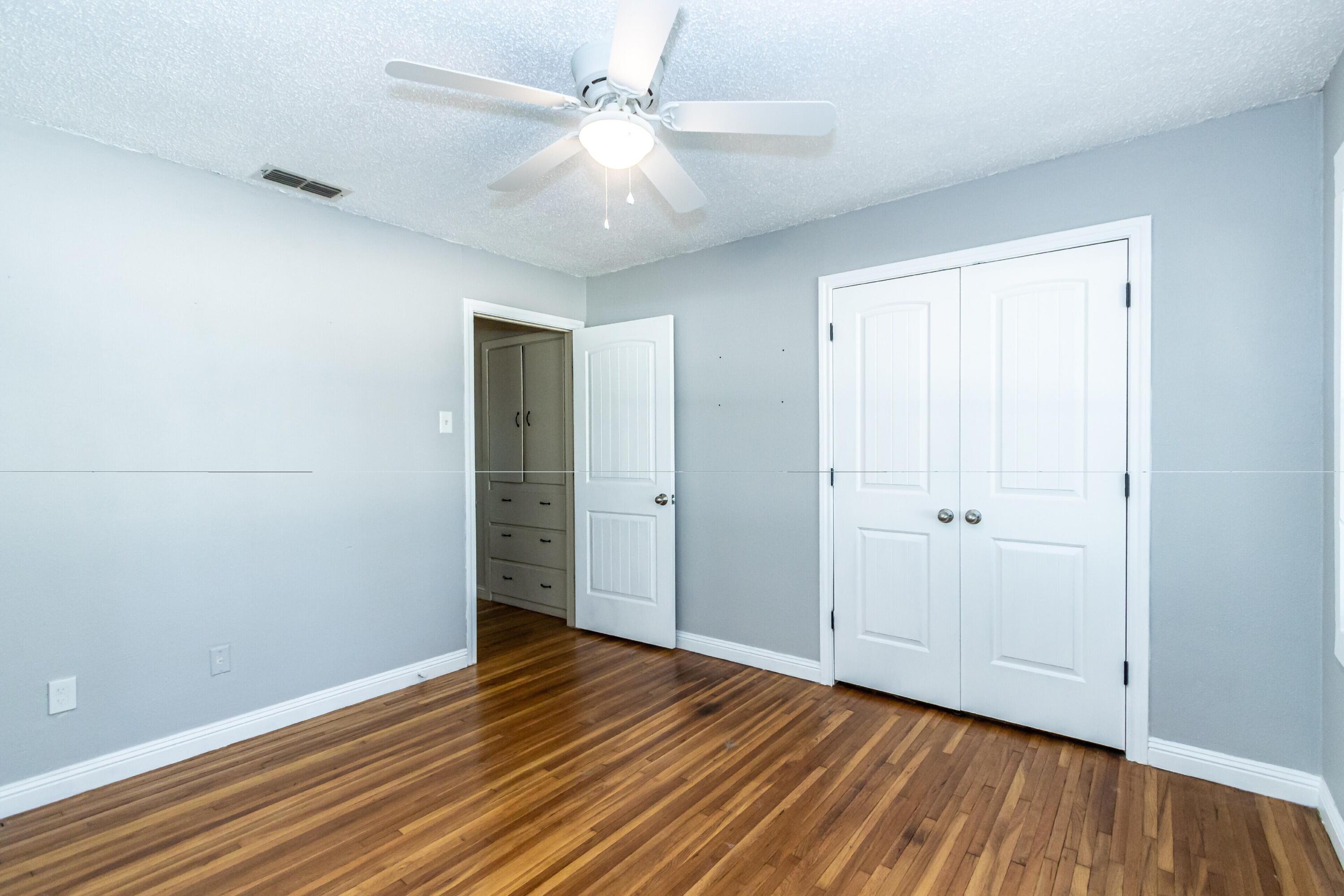 2611 44th Street Lubbock, TX 79413 - Photo 13 of 18 an empty room with wooden floor and a ceiling fan