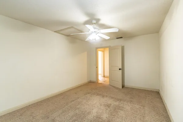 an empty room with a ceiling fan and a window