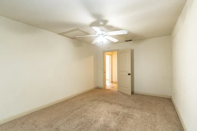 an empty room with a ceiling fan and a window