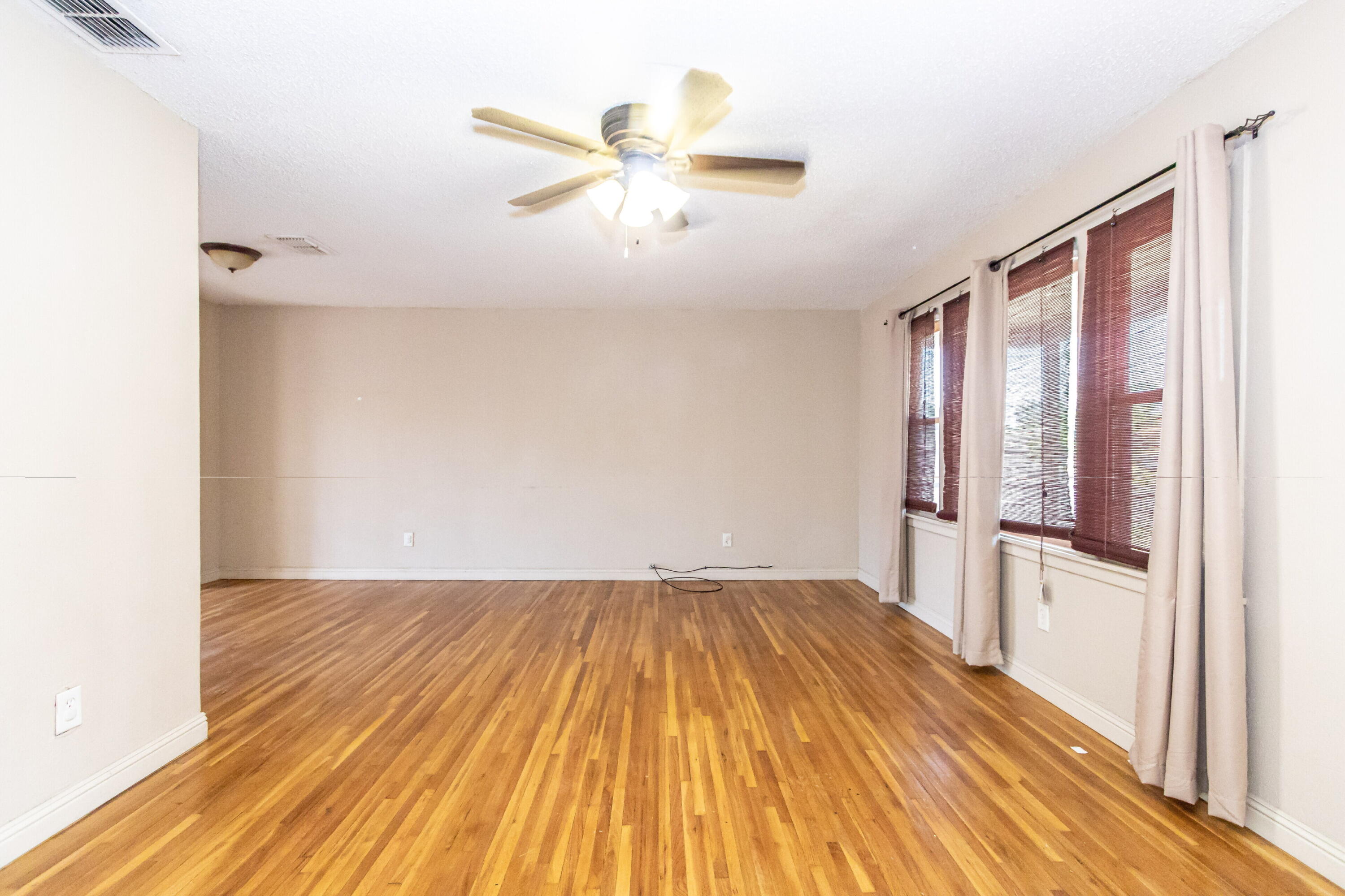 2611 44th Street Lubbock, TX 79413 - Photo 3 of 18 a view of a livingroom with wooden floor and a ceiling fan