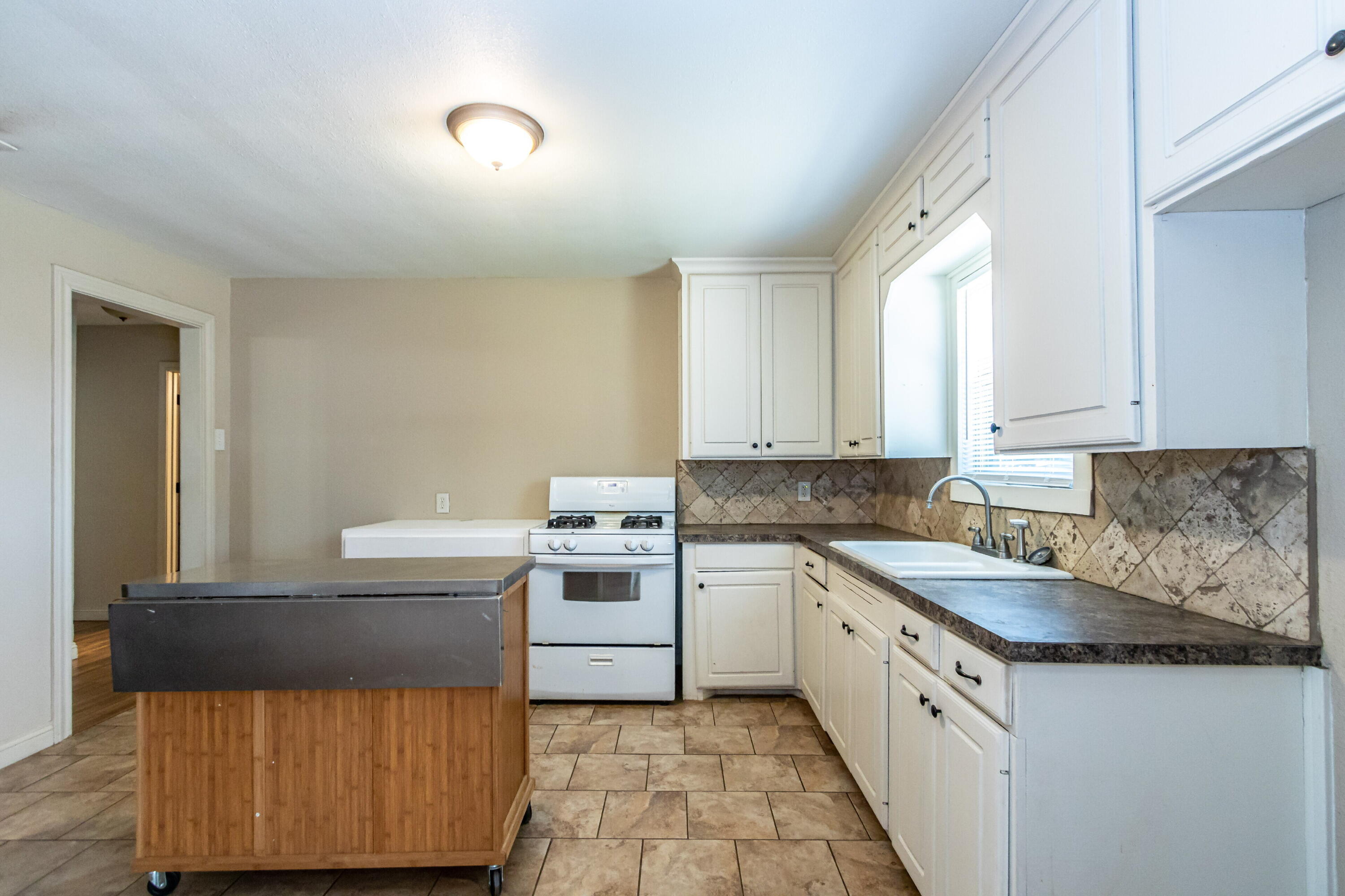 2611 44th Street Lubbock, TX 79413 - Photo 7 of 18 a kitchen with a sink and cabinets