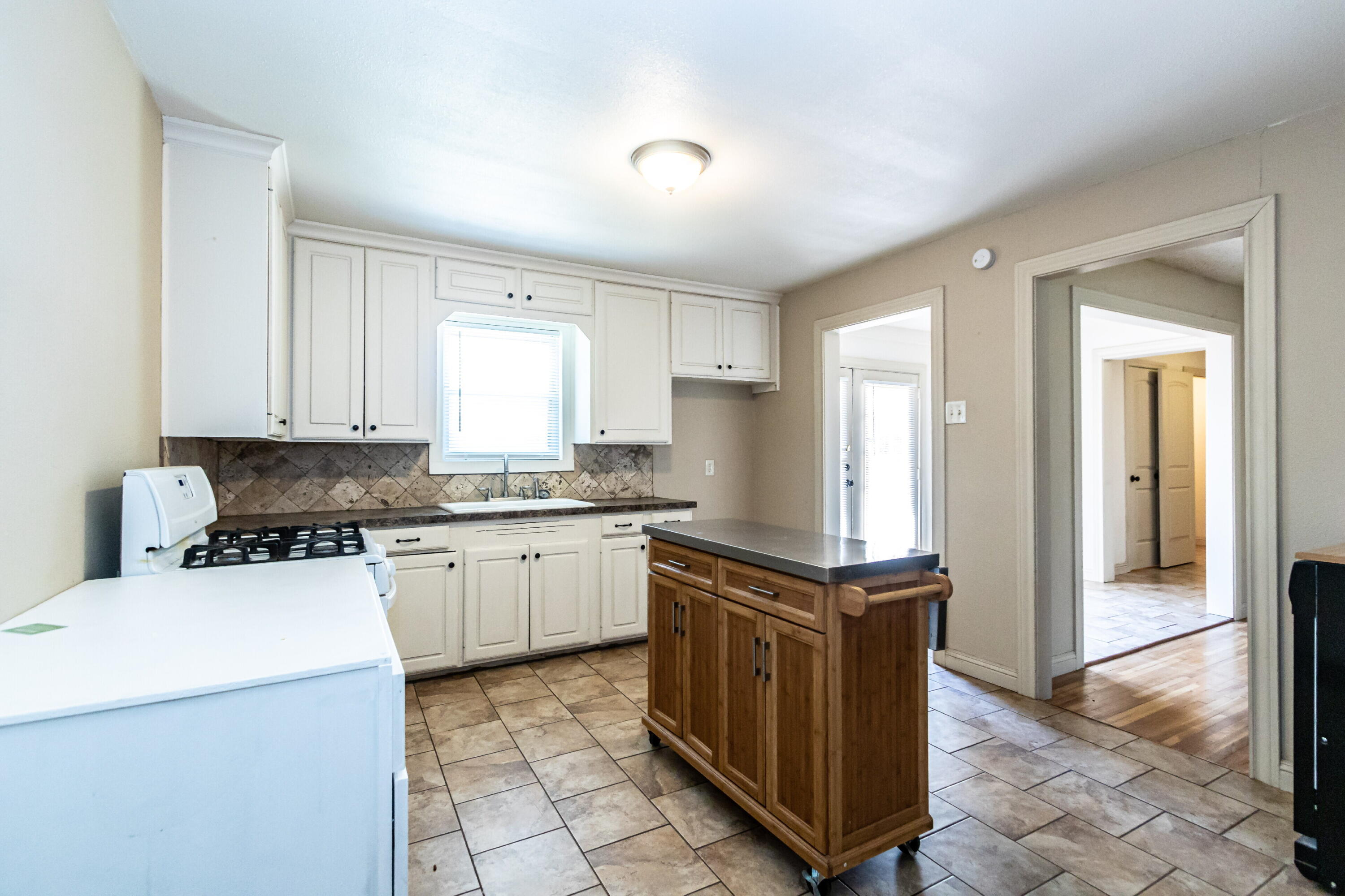 2611 44th Street Lubbock, TX 79413 - Photo 8 of 18 a kitchen with granite countertop a stove a sink and a refrigerator
