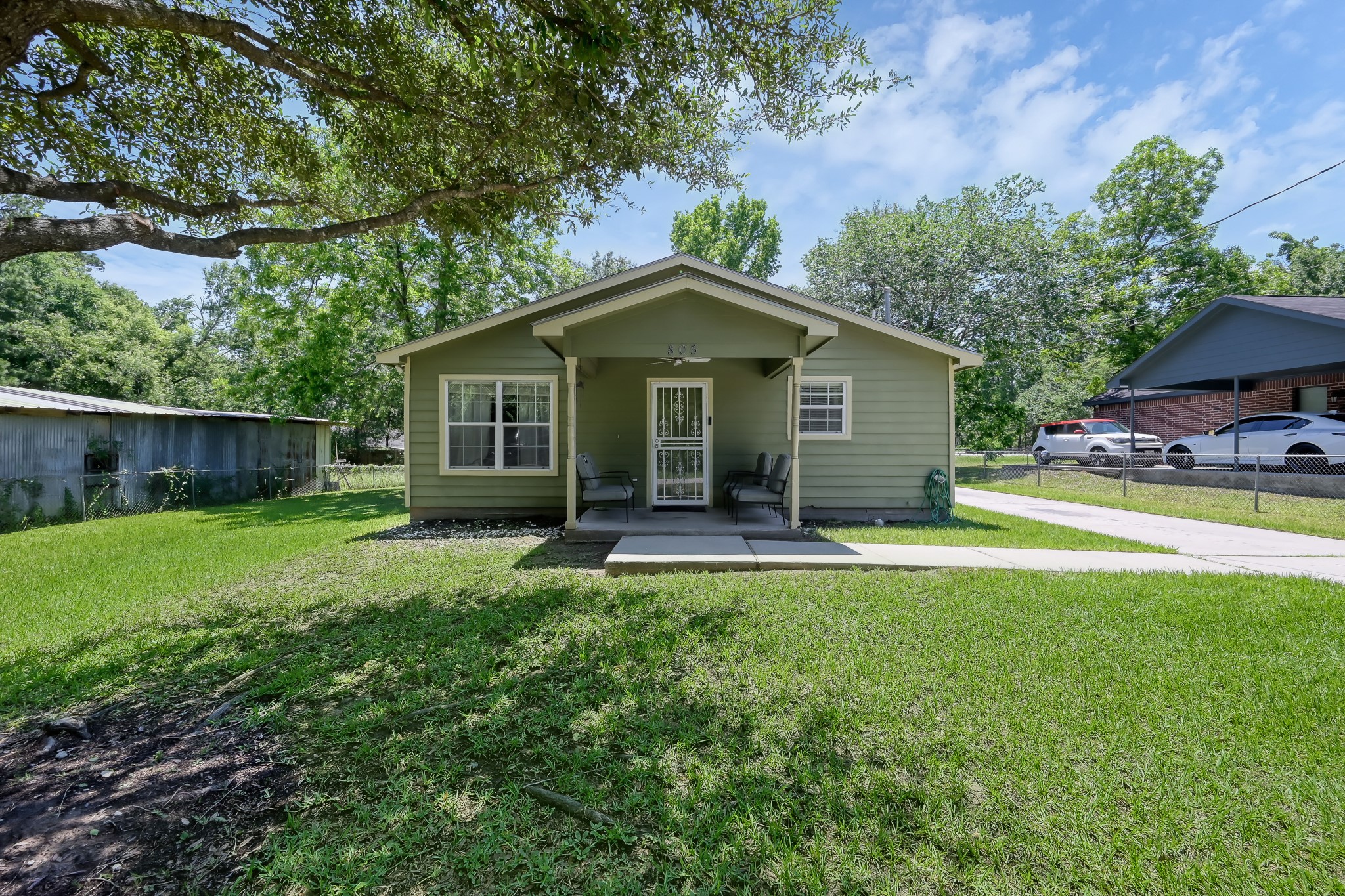 805 Webb Street Conroe, TX 77301 - Photo 2 of 19 a view of a house with a yard plants and a large tree