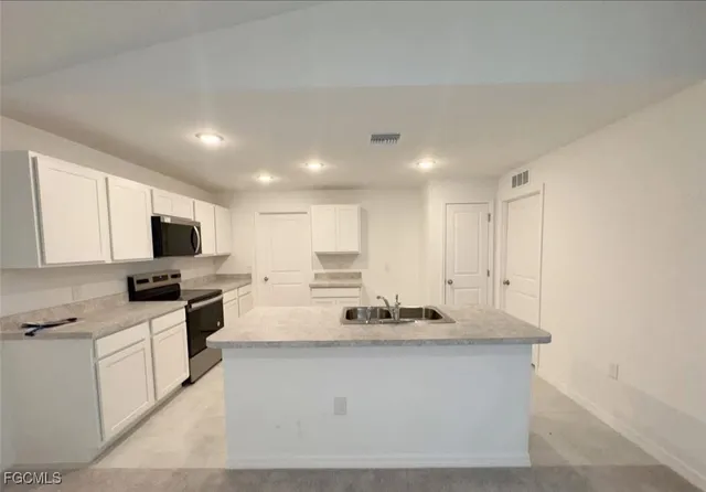 a kitchen with stainless steel appliances white cabinets and sink