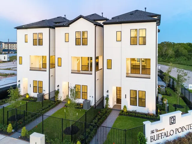 a view of a brick house with many windows and a table and chairs