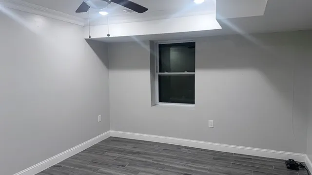 an empty room with wooden floor and hallway