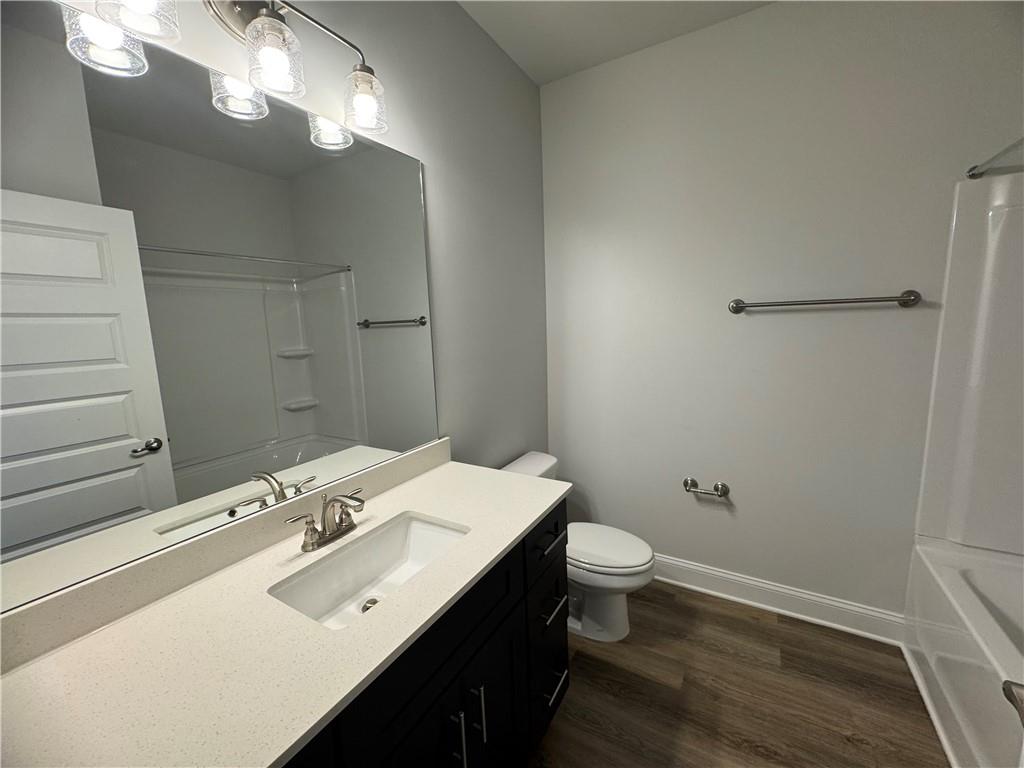 562 Walnut Crk Parkway Pendergrass, GA 30567 - Photo 10 of 20 a bathroom with a sink a toilet a light fixture and a mirror