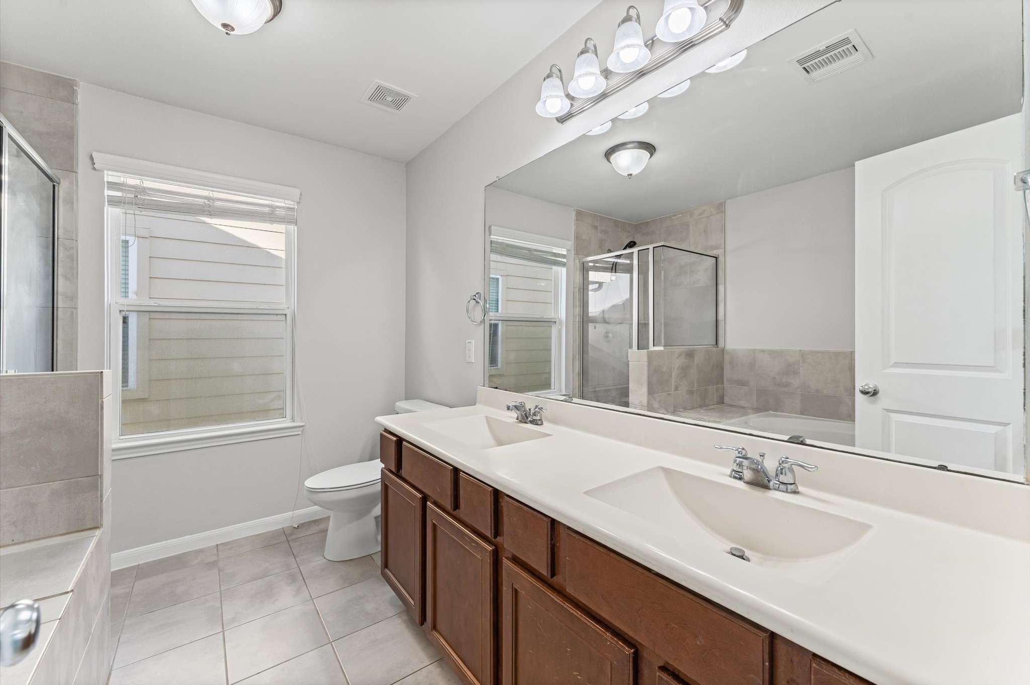 7018 Granite Terrace Lane Houston, TX 77083 - Photo 14 of 18 a bathroom with a sink double vanity granite tub and a mirror
