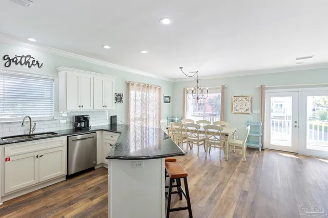 a kitchen with granite countertop a sink and dishwasher a stove with wooden floor