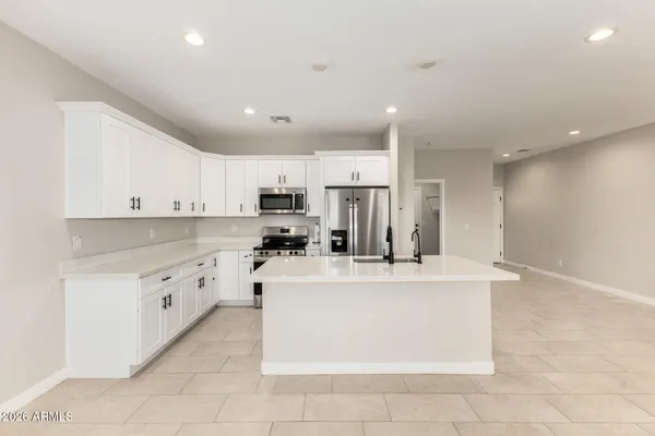 a large white kitchen with stainless steel appliances