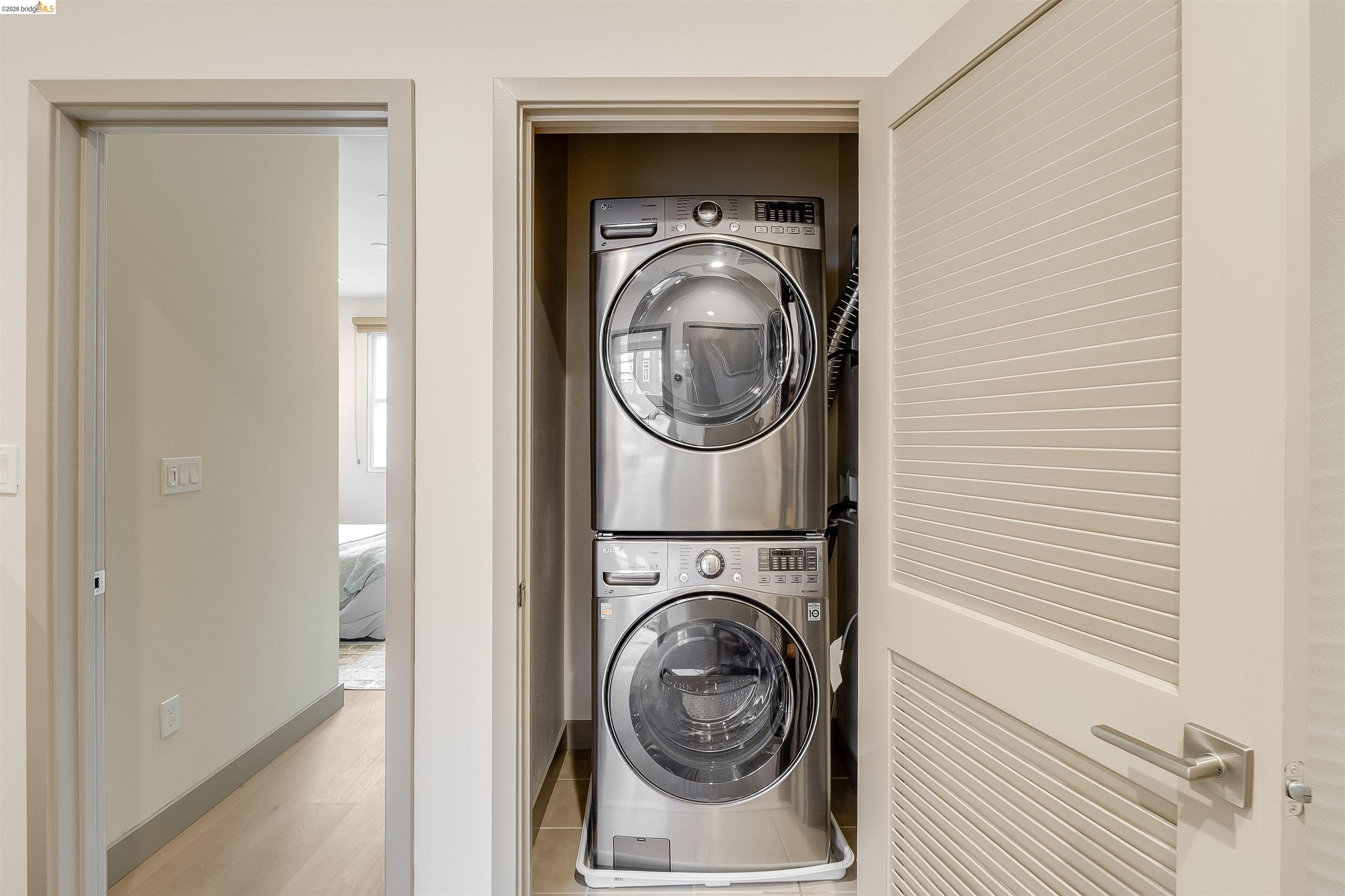 1357 Pullman Way Oakland, CA 94607 - Photo 21 of 37 Dedicated laundry closet with stacked stainless steel washer and dryer units
