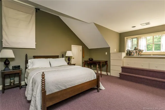 a bedroom with a bed a table and chair