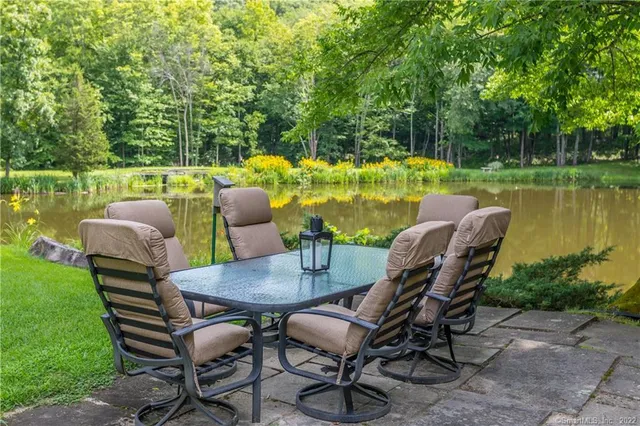 a view of a chairs and table in patio and a yard