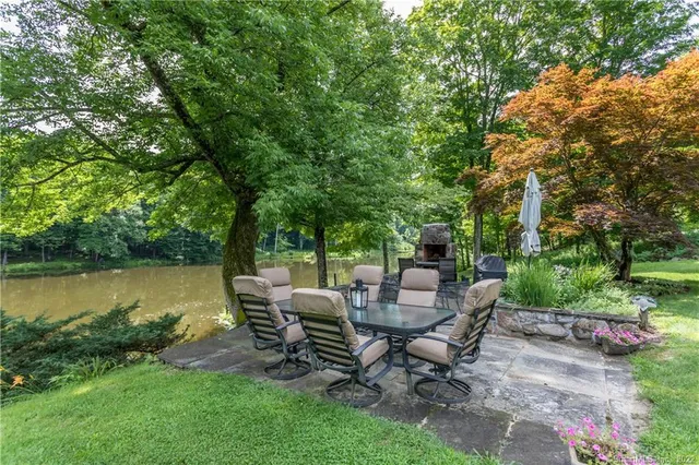 a view of a patio with table and chairs potted plants and large tree