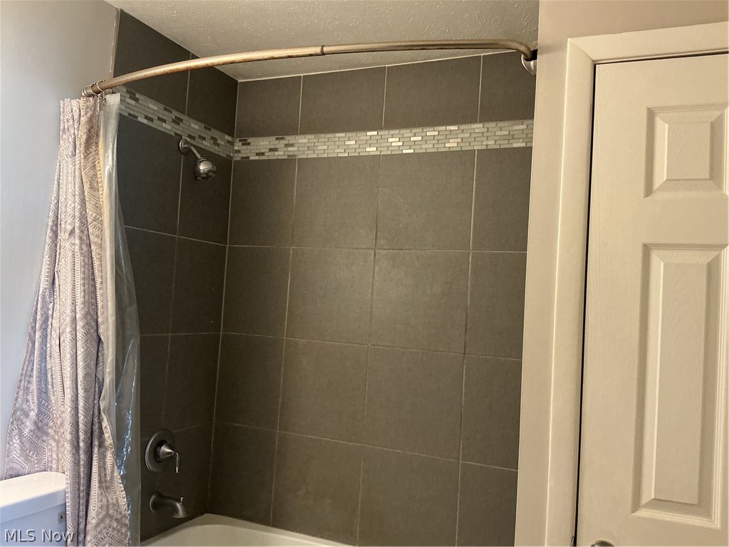 1850 Merle Road Salem, OH 44460 - Photo 16 of 35 Bathroom featuring shower / tub combo and a textured ceiling