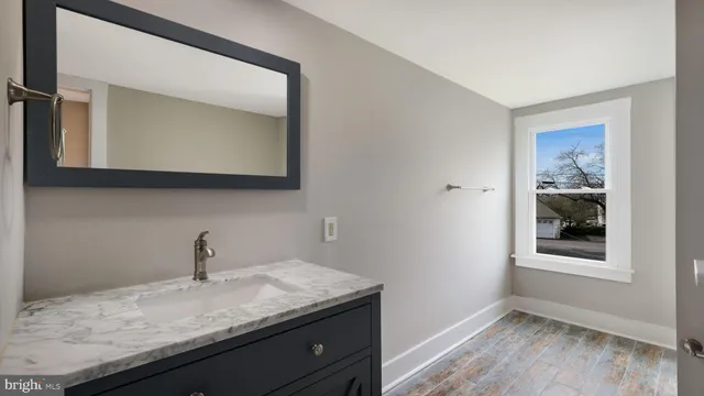 a bathroom with a granite countertop sink and a mirror