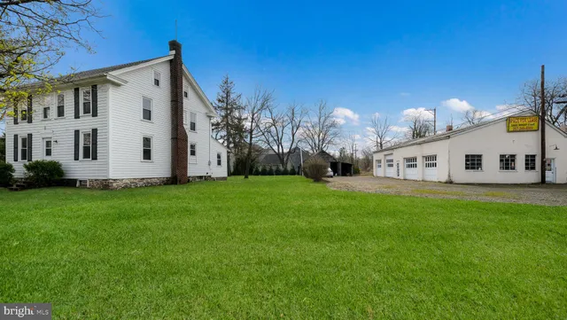 a view of a white house with a big yard