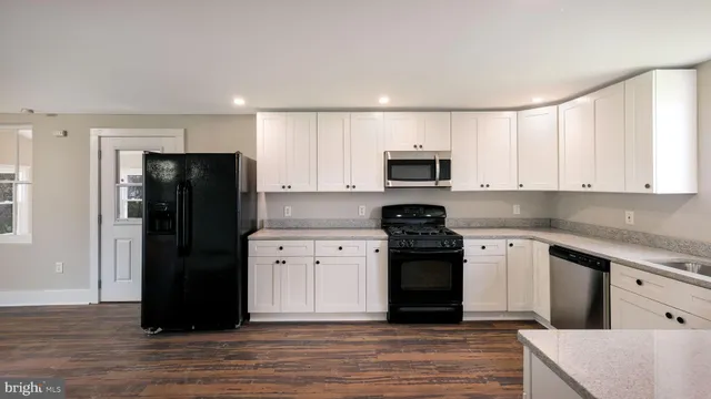a kitchen with a refrigerator and a stove top oven