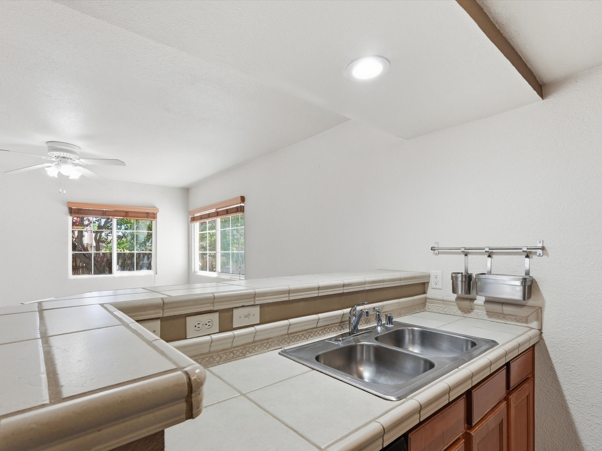 2210 Miguel Chavez Road, Unit 411 Santa Fe, NM 87505 - Photo 11 of 59 Kitchen area with dual sink for multi-purpose use and a tiled countertop.