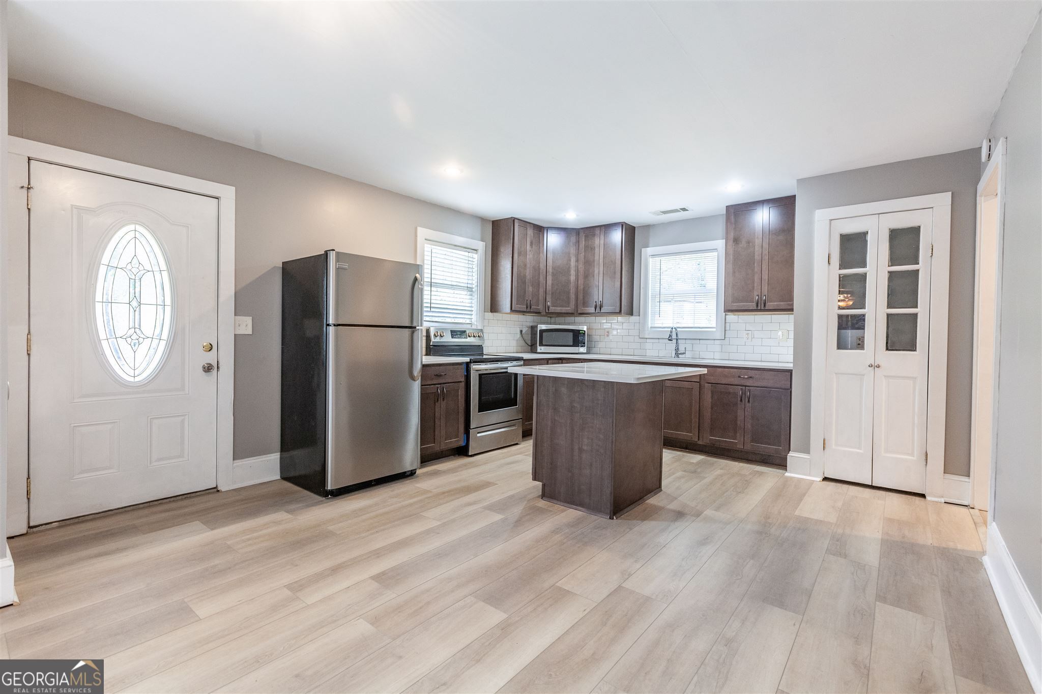 45 Bridge Street Senoia, GA 30276 - Photo 6 of 19 a kitchen with stainless steel appliances granite countertop a refrigerator a sink a stove and a wooden floors