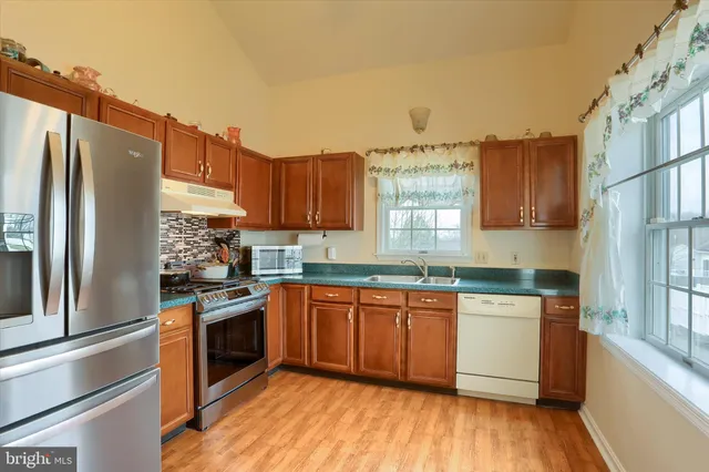 a kitchen with stainless steel appliances granite countertop a stove a sink dishwasher and a refrigerator
