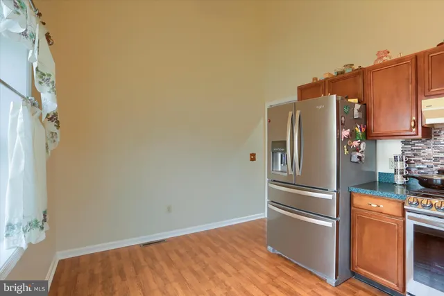 a kitchen with stainless steel appliances a refrigerator and a stove top oven