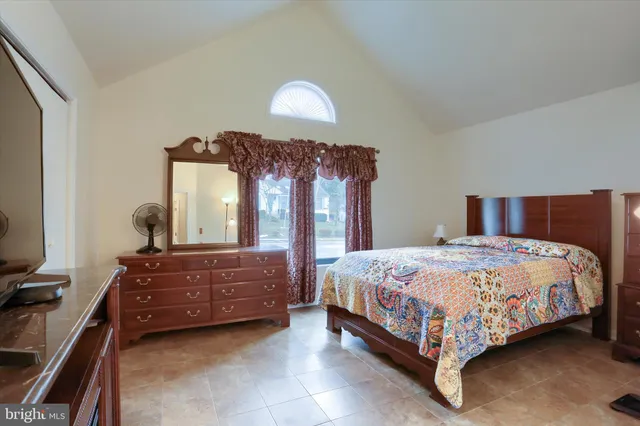a bedroom with a bed lamp and dresser