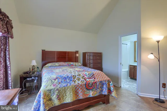 a bedroom with a bed and a lamp with the dresser