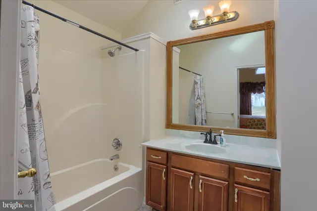 a bathroom with a granite countertop sink a mirror a vanity and a bathtub