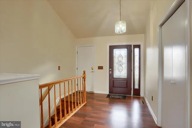 a view of a hallway with wooden floor and staircase