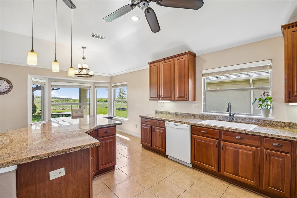 9221 Perimeter Street Denton, TX 76207 - Photo 11 of 36 a large kitchen with kitchen island granite countertop a sink and dishwasher a stove with wooden floor