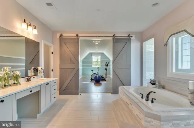 a bathroom with a tub sink and mirror