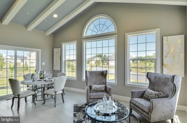 a dining room with furniture a fireplace and large windows